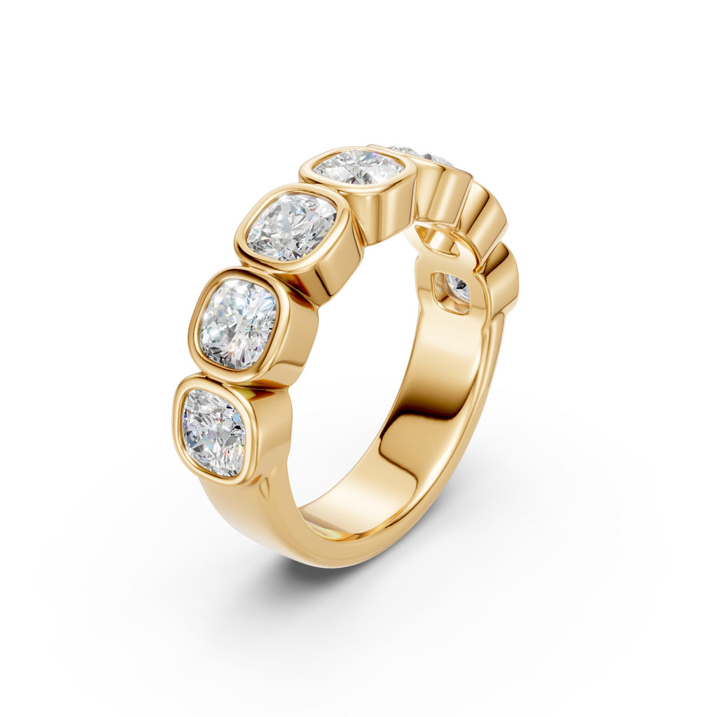 Angled close-up of the yellow gold Seven-Stone Cushion Bezel Band, showing seven cushion-cut diamonds in smooth full bezel settings.