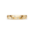 Front view of the yellow gold Thirteen Flush Diamond Straight Band showing round diamonds in a scattered, alternating arrangement