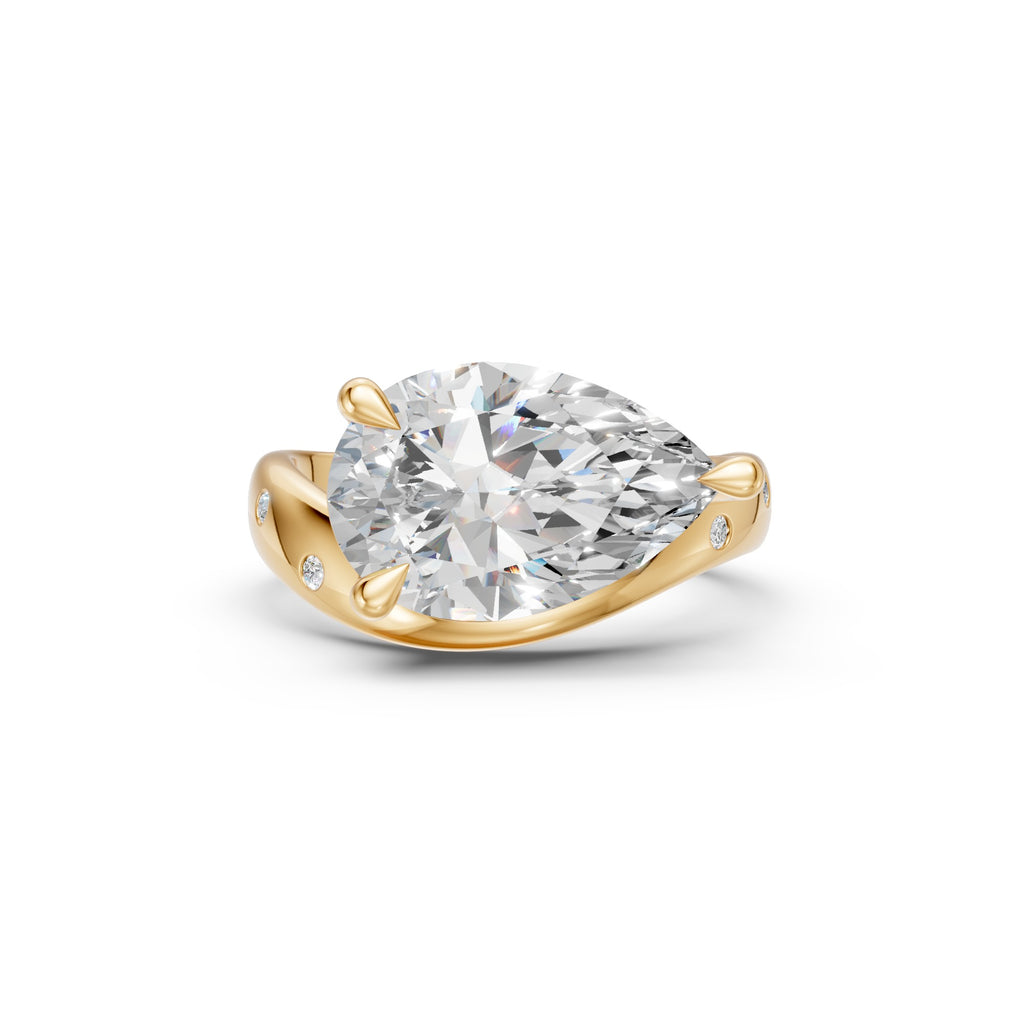Front view of pear-shaped diamond ring with curved yellow gold band and flush-set accents